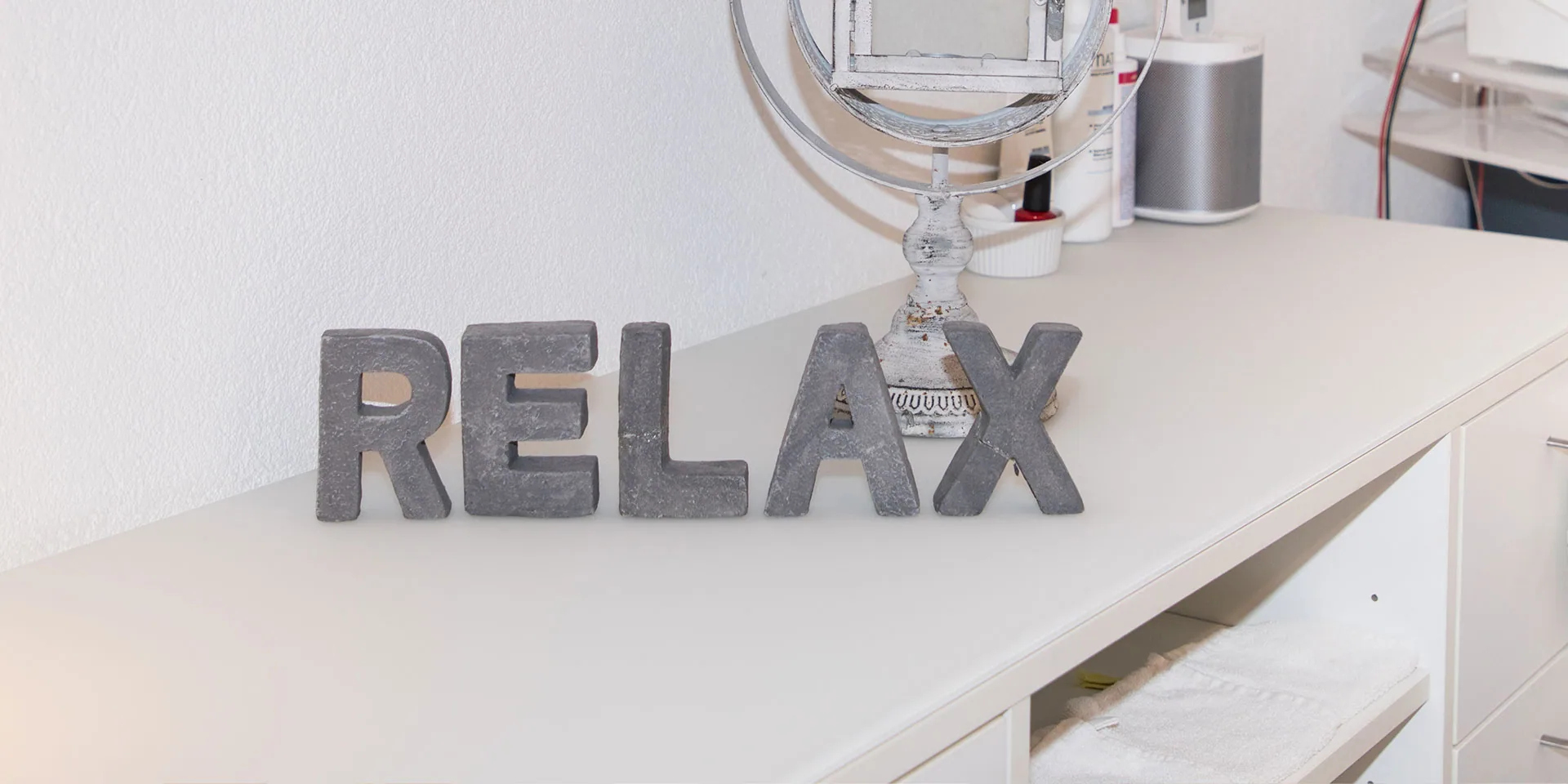 Ruhiger Behandlungsraum mit Schriftzug RELAX
